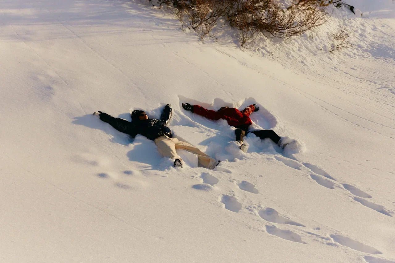 Two people walking in a snowy mountain landscape, representing steady movement, recovery and resilience