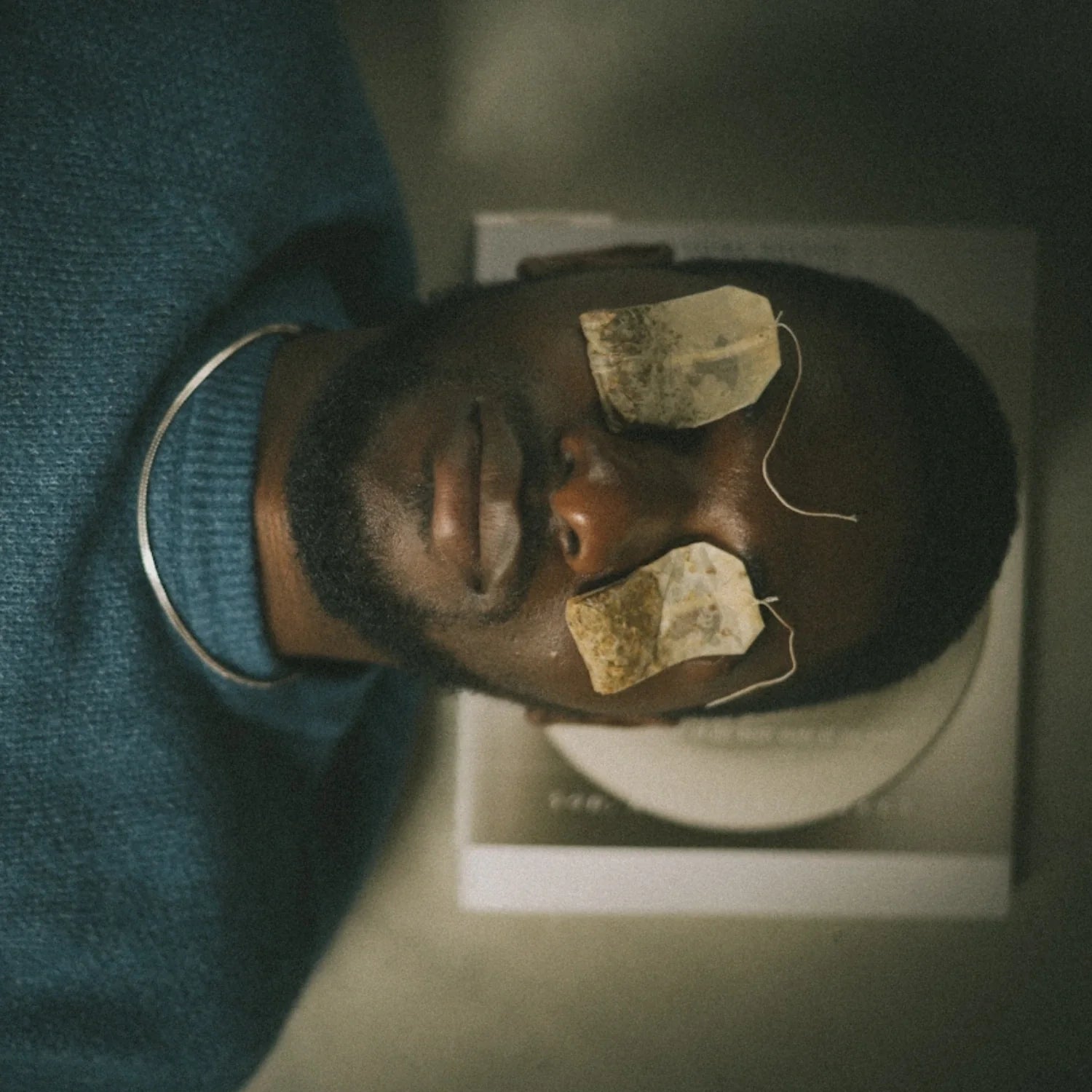 Man resting with tea bags on his eyes, symbolizing immune balance and recovery
