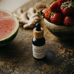 Ancient Therapy's Shilajit Drops bottle on a wooden surface with fruits