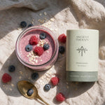Ancient Therapy Ashwagandha bredvid en bärsmoothie med havre och färsk frukt