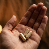 Tre Ancient Therapy Ashwagandha-kapslar i en öppen handflata